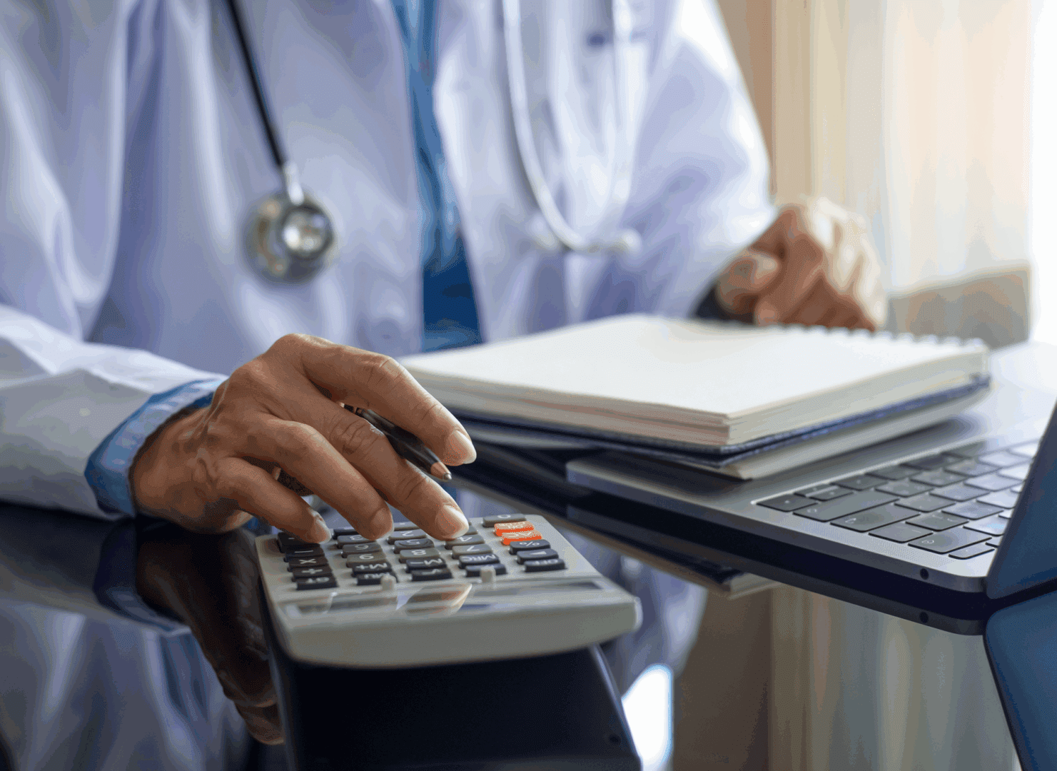 Physician working with laptop and notes
